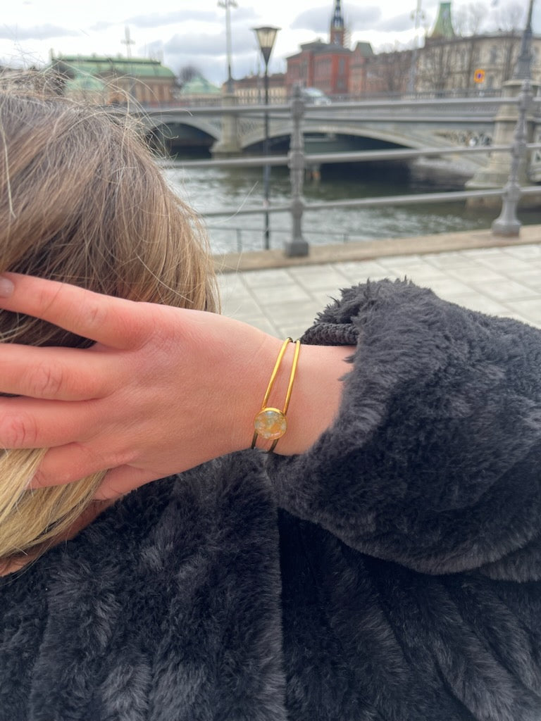 En kvinna med ett armband i guld från Nayuga Jewels