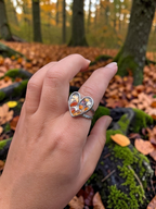 Citrinmagi hjärtformad ring med naturlig karneol i silverpläterat stål med tvinnad kant, buren på ett finger i skog.