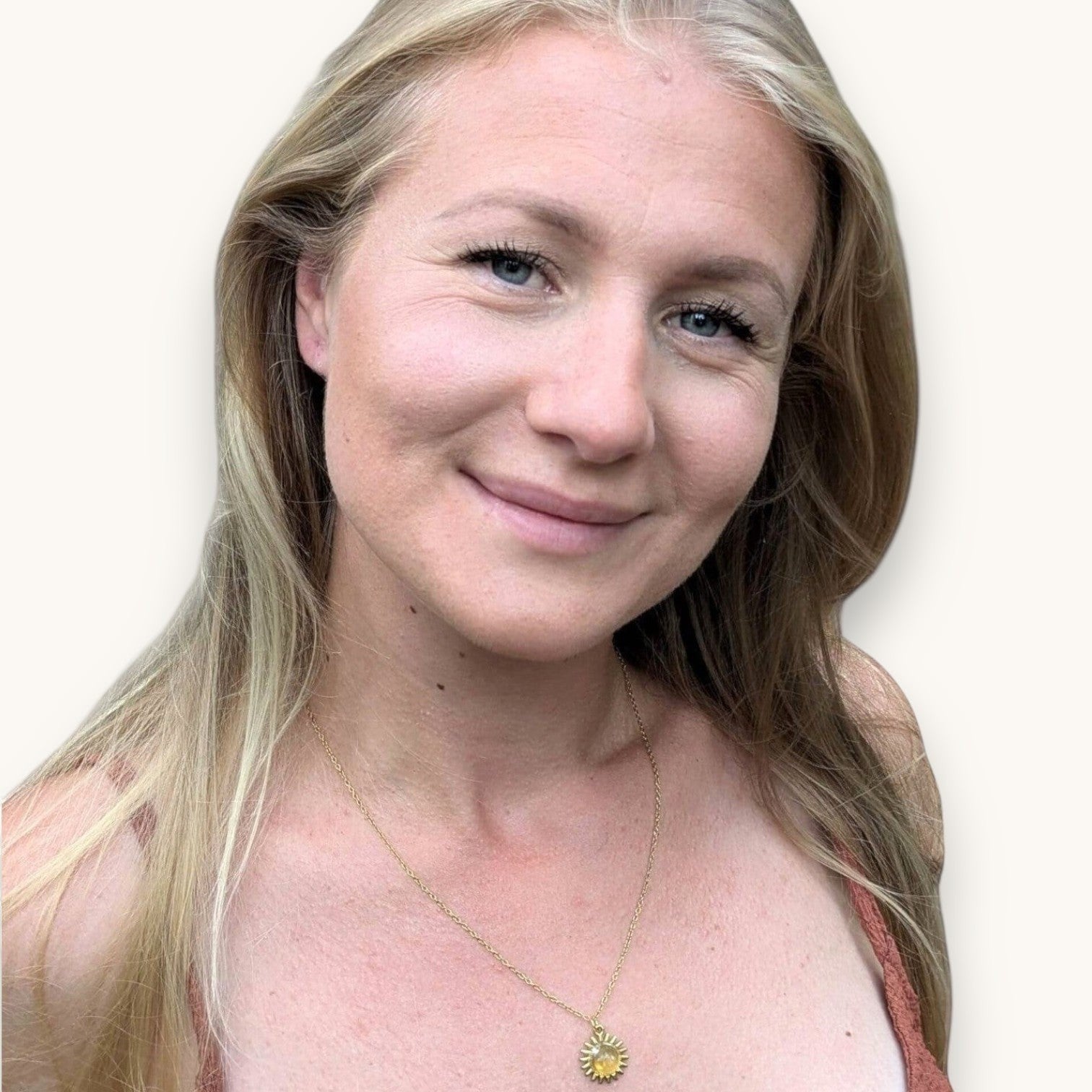 Glad kvinna med ett solformat halsband med citrin från Nayuga Jewels. Hon är lyckig och skrattar.
