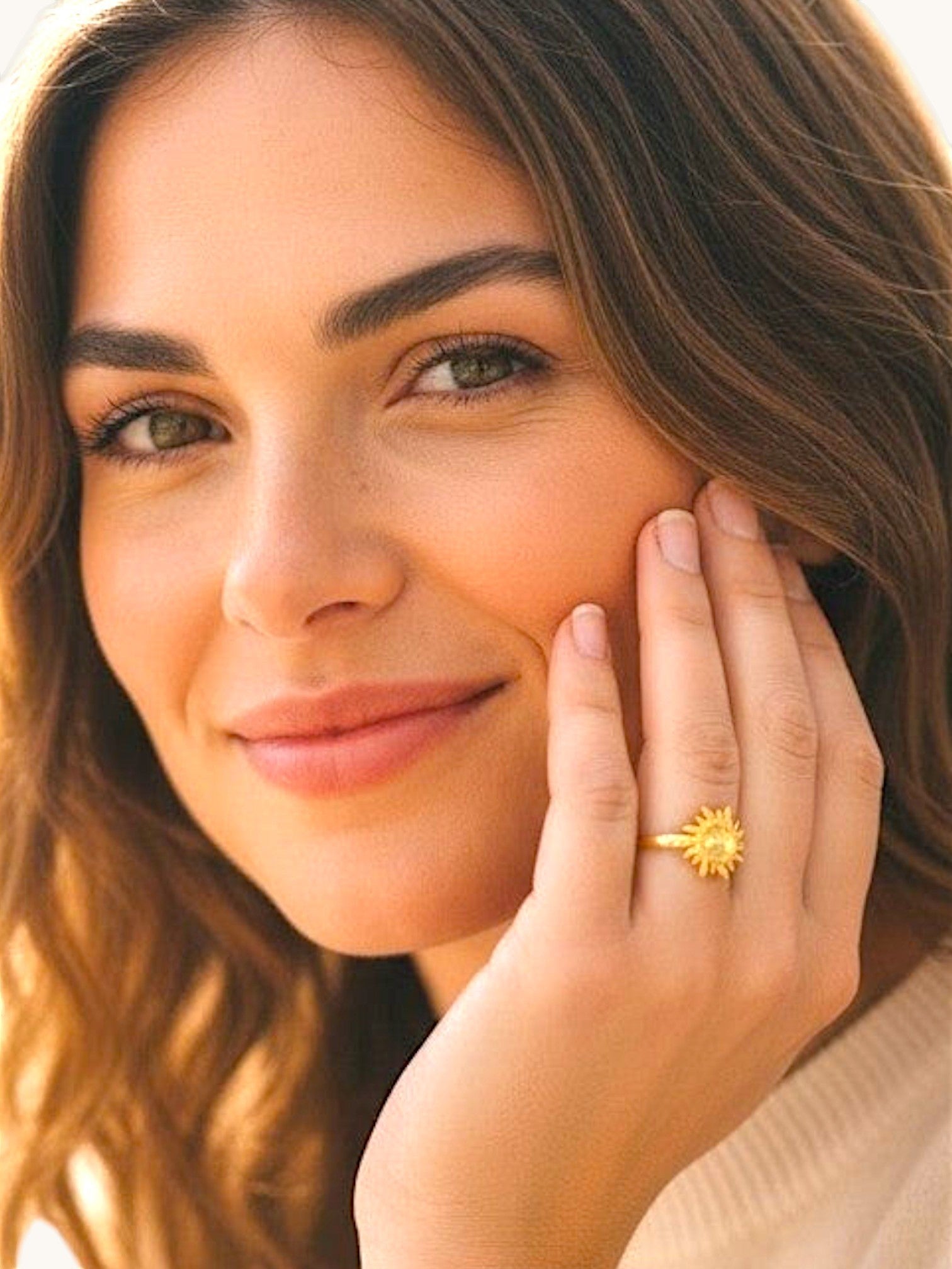 Nayuga Jewels Solstråle ring i guldpläterad design med solmotiv buren av en kvinna för en elegant och varm look.