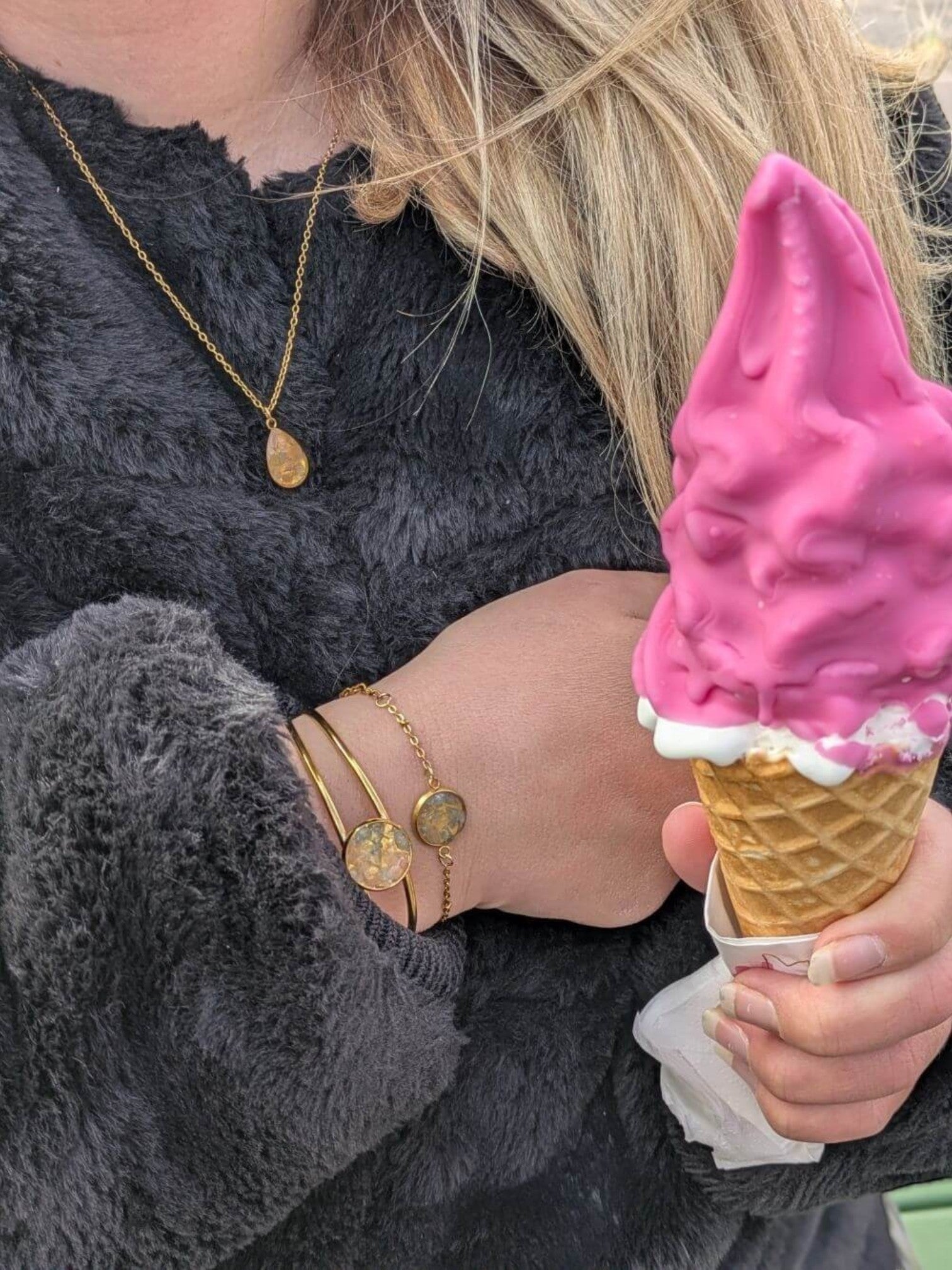 Citrinmagi armband med rosenkvarts och akvamarin i guldpläterat stål, buret av en person med en rosa glass.