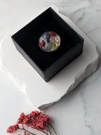 Citrinmagi handgjord chakra-ring i silverpläterat stål med sju olikfärgade kristaller i en svart ask.