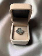 Citrinmagi ring med råa citrinkristaller i rund silverpläterad infattning placerad i en beige smyckesask