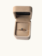 Citrinmagi guldring med fyrkantig ametistkristall i en beige sammetsask för en elegant och sofistikerad look.