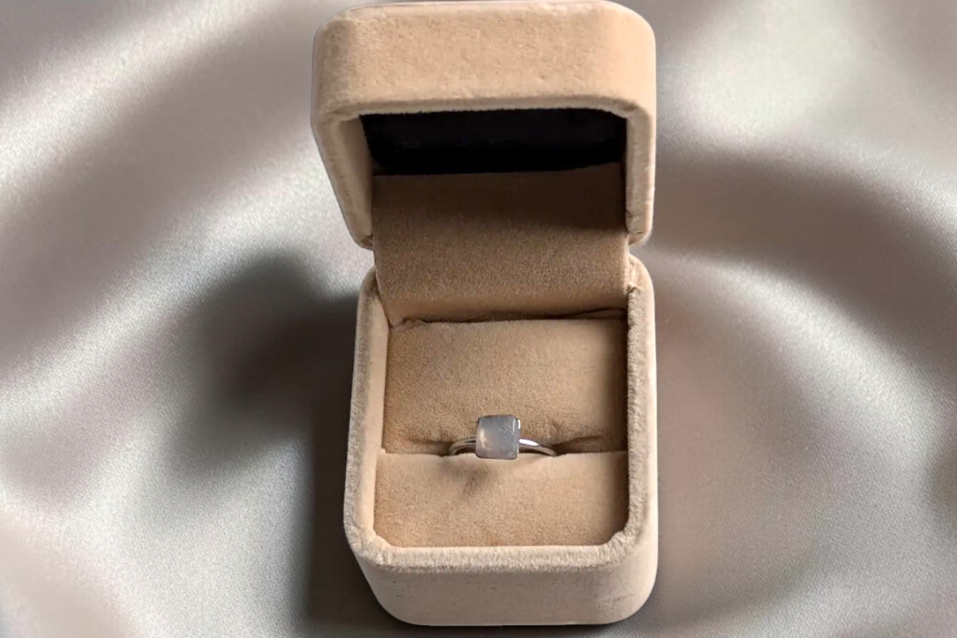 Citrinmagi fyrkantig silverring med äkta månstenskristaller i en elegant beige smyckesask på sidenliknande tyg.