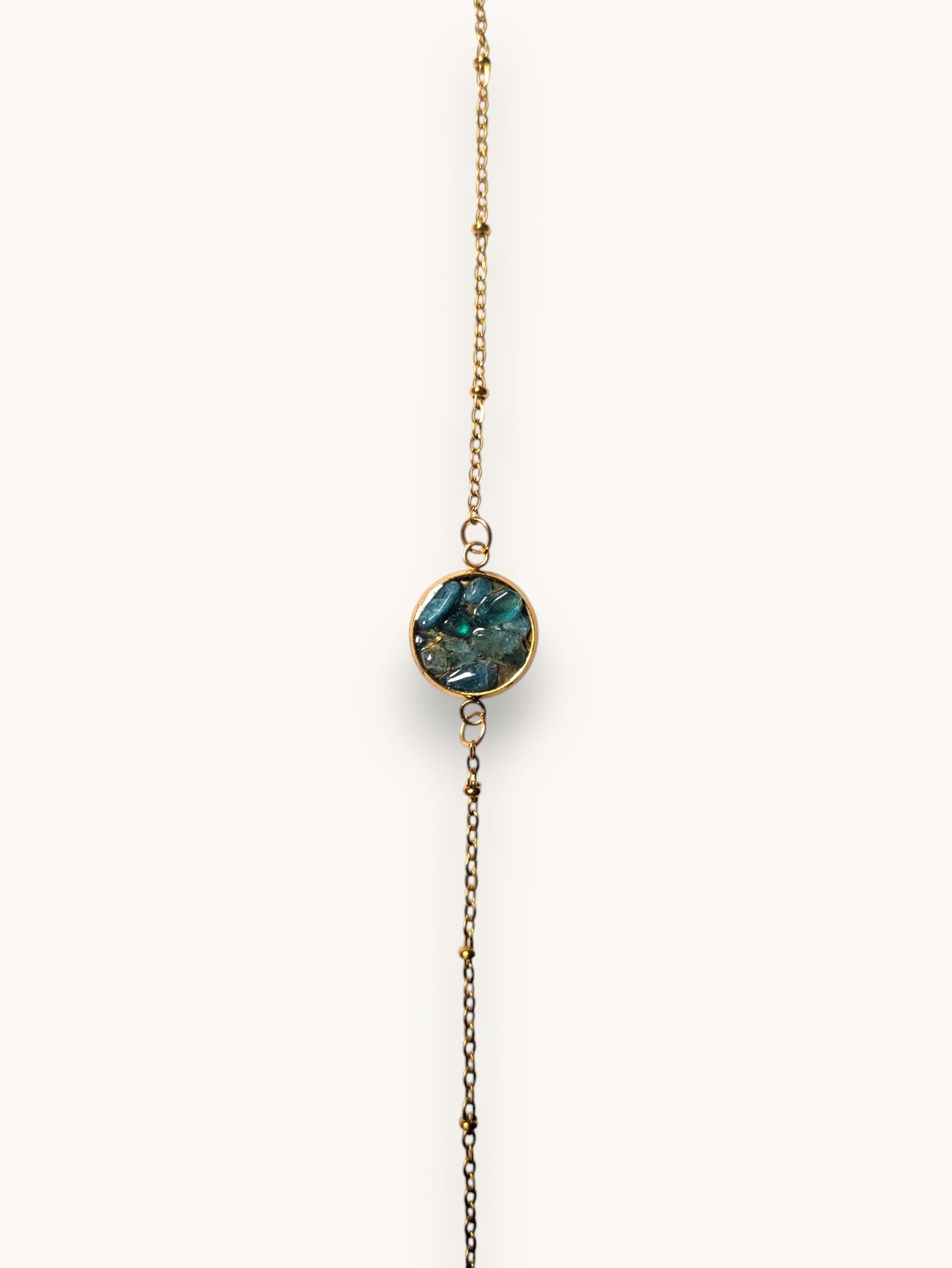 Citrinmagi armband i guld med en rund detalj fylld av skimrande blå stenar och en fin justerbar kedja.
