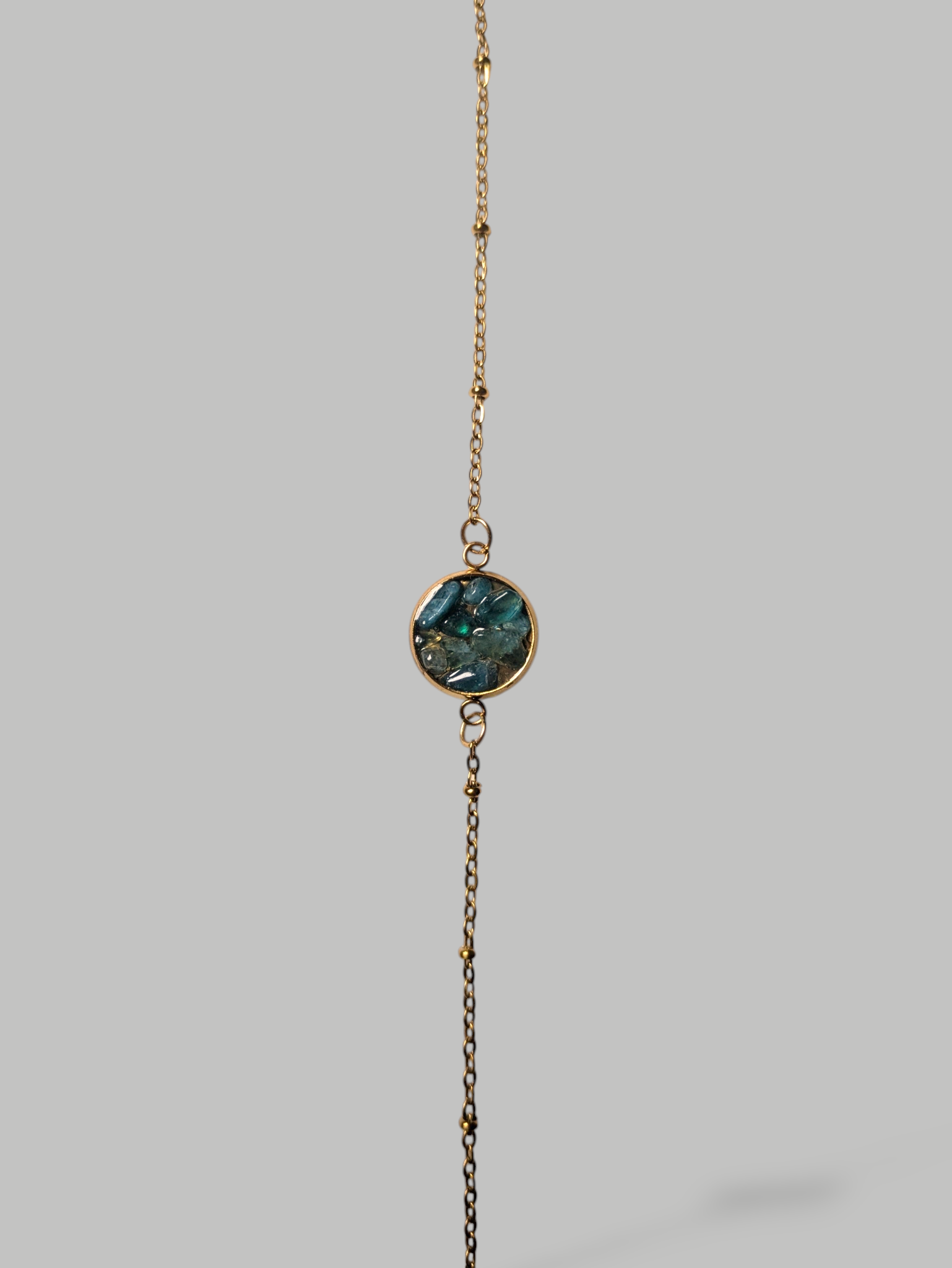 Citrinmagi armband i guld med en rund detalj fylld av skimrande blå stenar och en fin justerbar kedja.