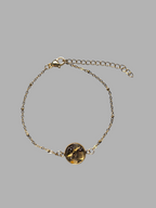 Citrinmagi armband i guldfärgad metall med en rund bärnstensliknande sten och dekorativa kulor på kedjan.