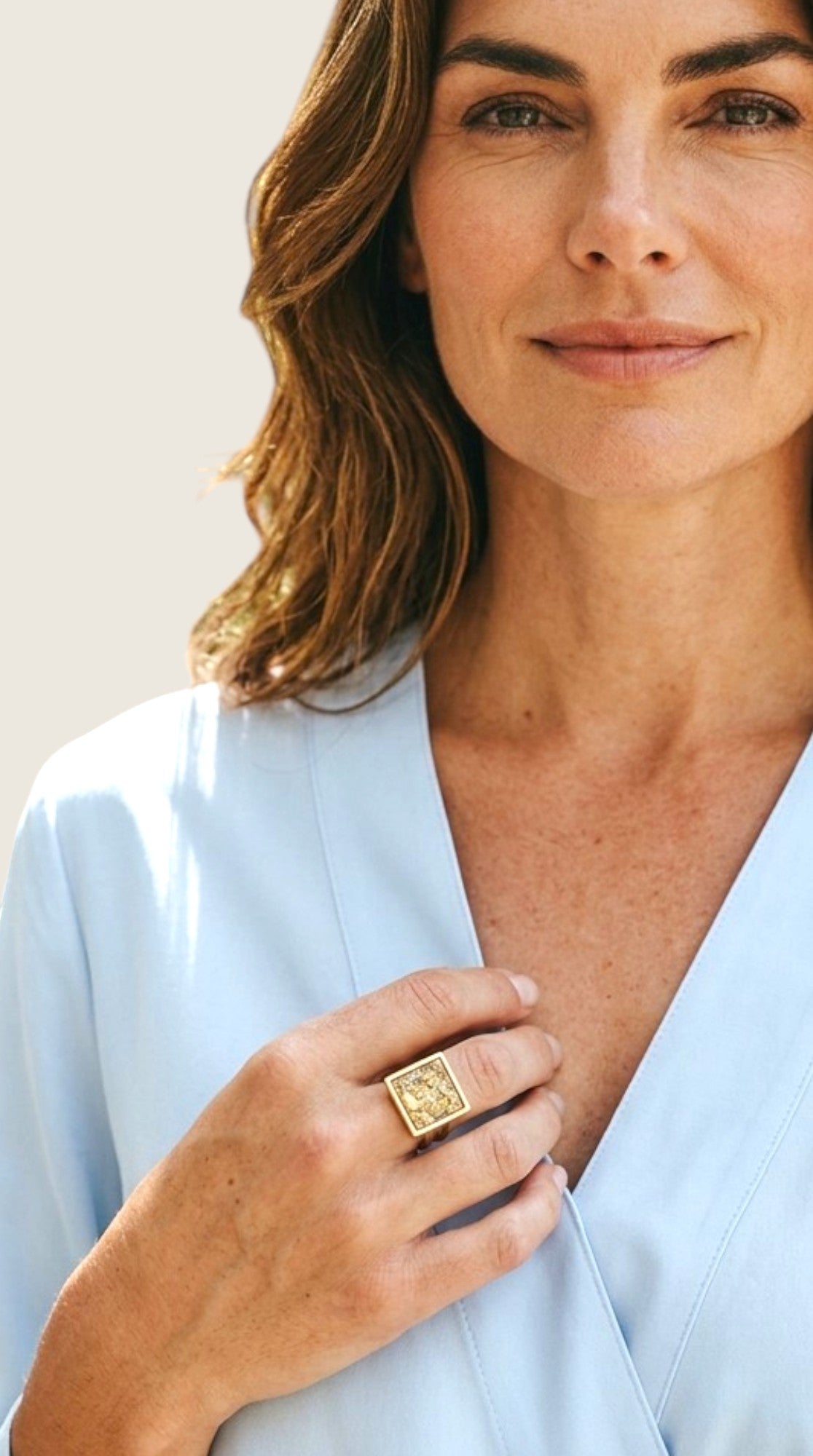 Kvinna bär en elegant Nayuga Jewels guldring med fyrkantig citrinkristall på fingret för en lyxig och modern stil.
