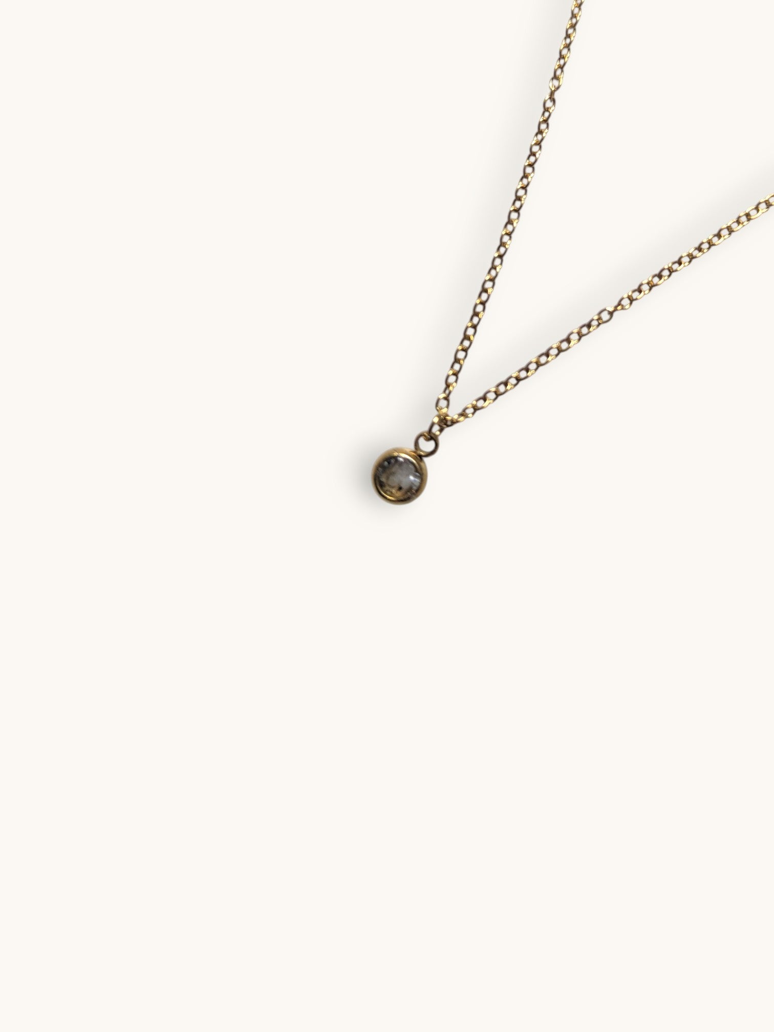 Citrinmagi guldtonat halsband med en minimalistisk kedja och en gnistrande sten infattad i en rund ram.