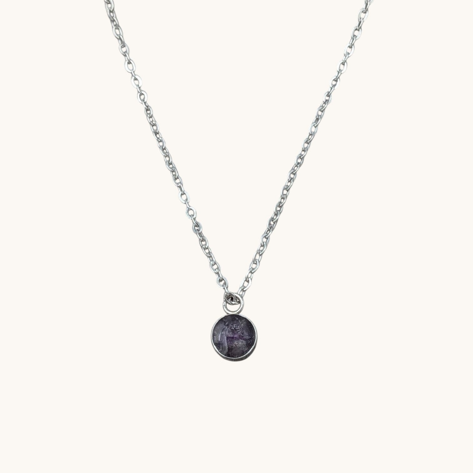 Nayuga Jewels halsband med rund ametistkristall i silverfärgad infattning och kedja i rostfritt stål.