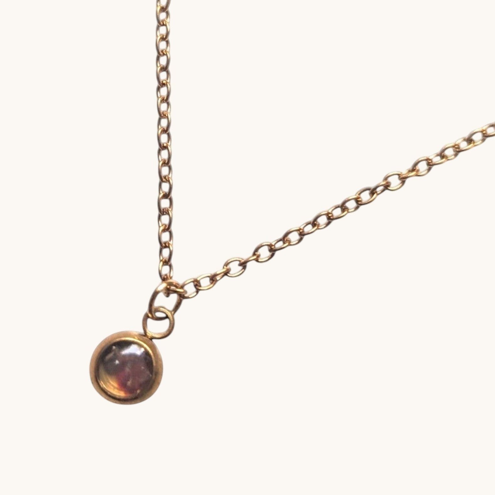 Citrinmagi halsband i antik mässing med en minimalistisk rund stenberlock på en nätt kedja mot en vit marmoryta.