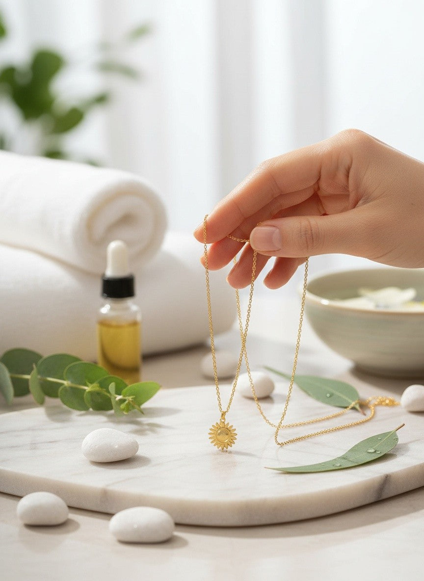 Citrinmagi halsband med citrin i solformad 18k guldpläterad fattning, hålls i en hand i en rofylld spa-miljö.