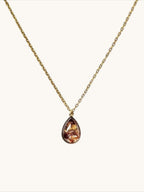 Citrinmagi halsband med droppformad granat i guldpläterad infattning på en tunn guldkedja.