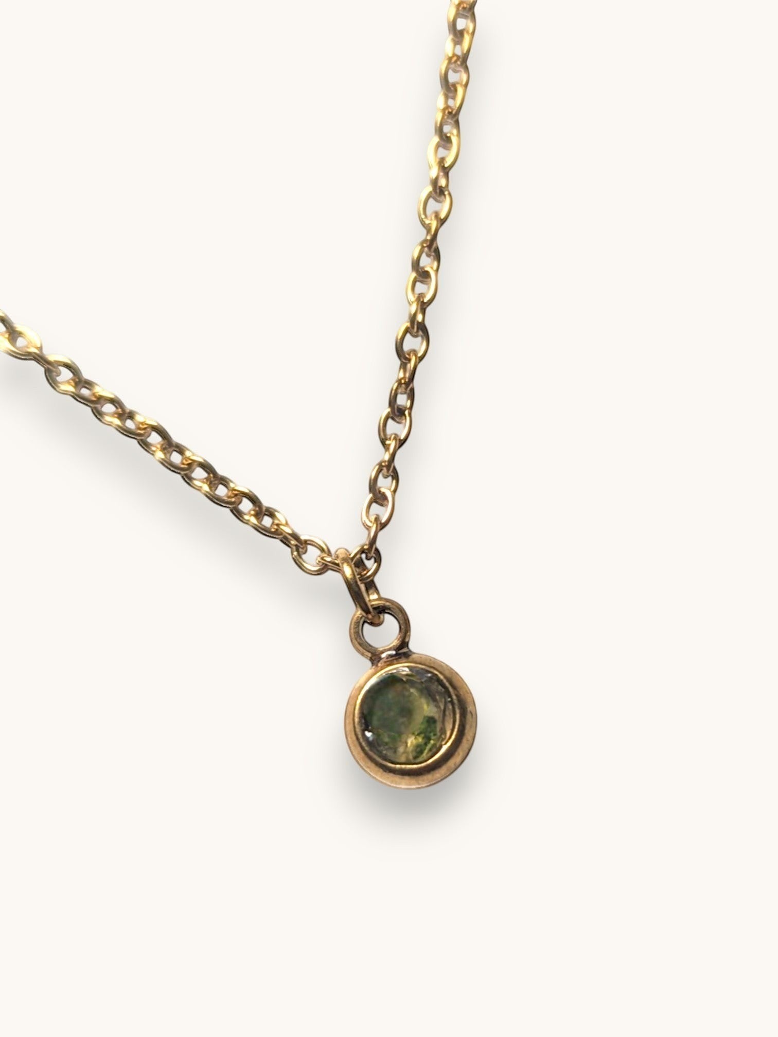 Nayuga Jewels halsband i antik guldton med en liten rund olivgrön sten på en klassisk länk-kedja.