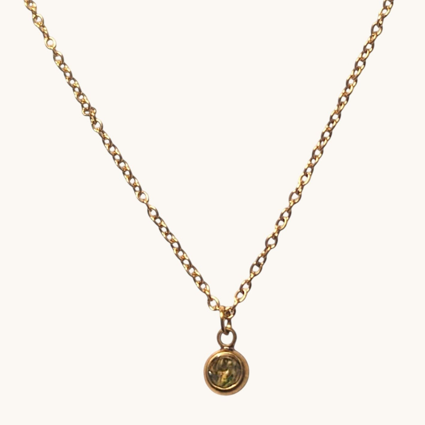 Nayuga Jewels halsband i antik guldton med en liten rund olivgrön sten på en klassisk länk-kedja.