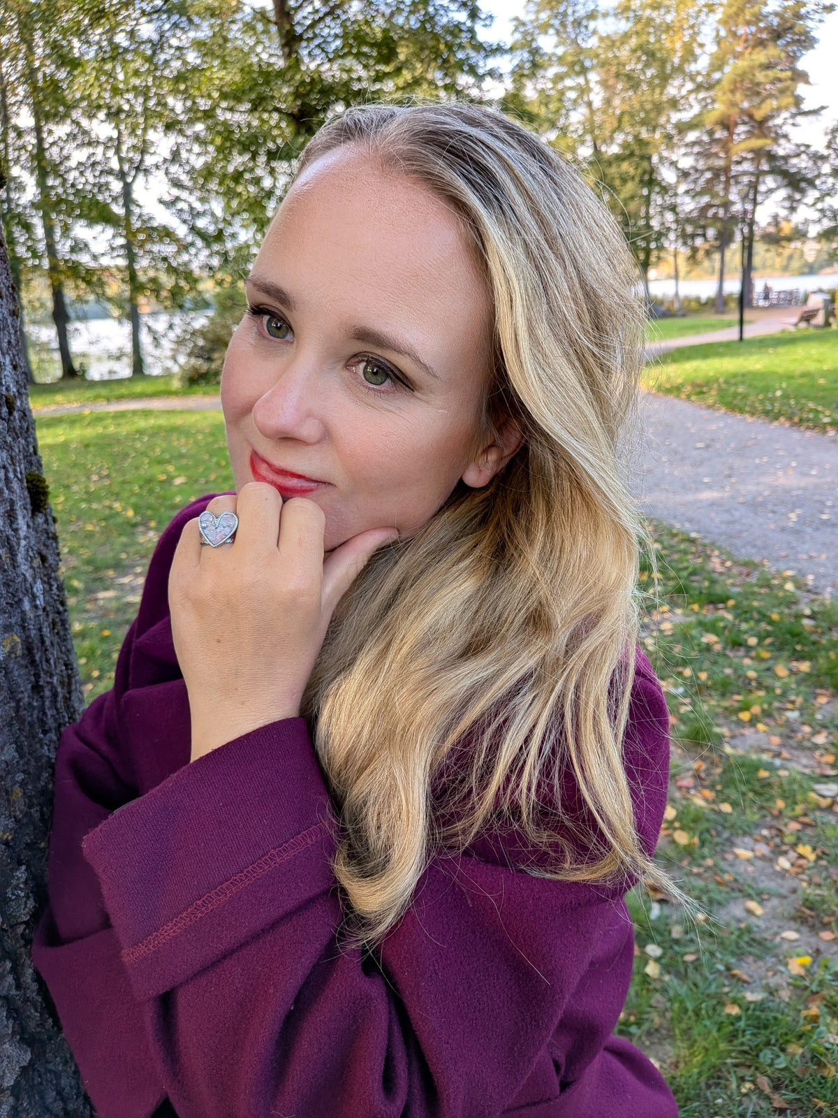 Kvinna bär en elegant hjärtformad Citrinmagi ring i silver med texturerad yta i en vacker höstpark.