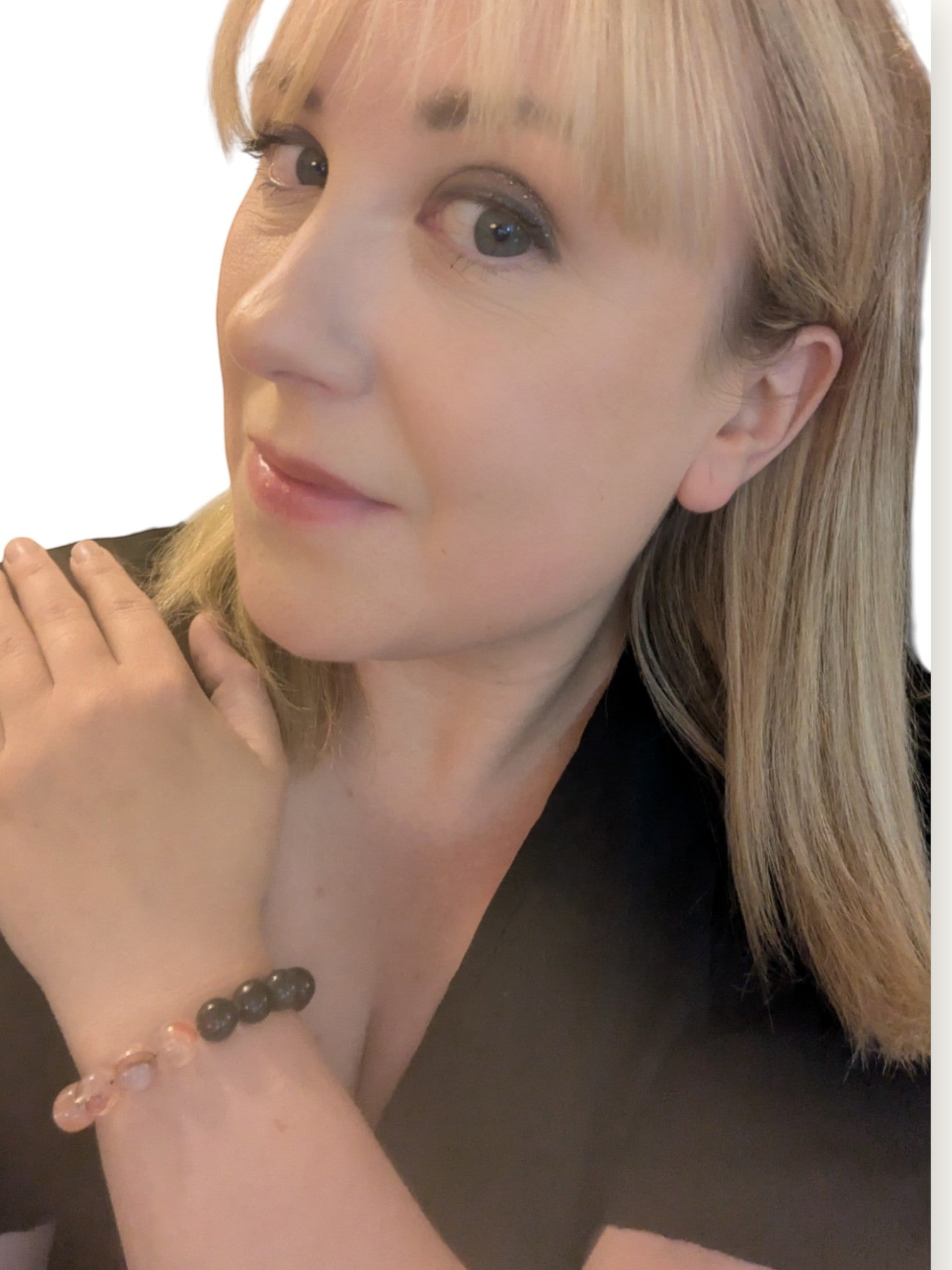 Kvinna bär ett elastiskt Citrinmagi kristallarmband med karneol, bergkristall, eldkvarts och larvikitt på handleden.