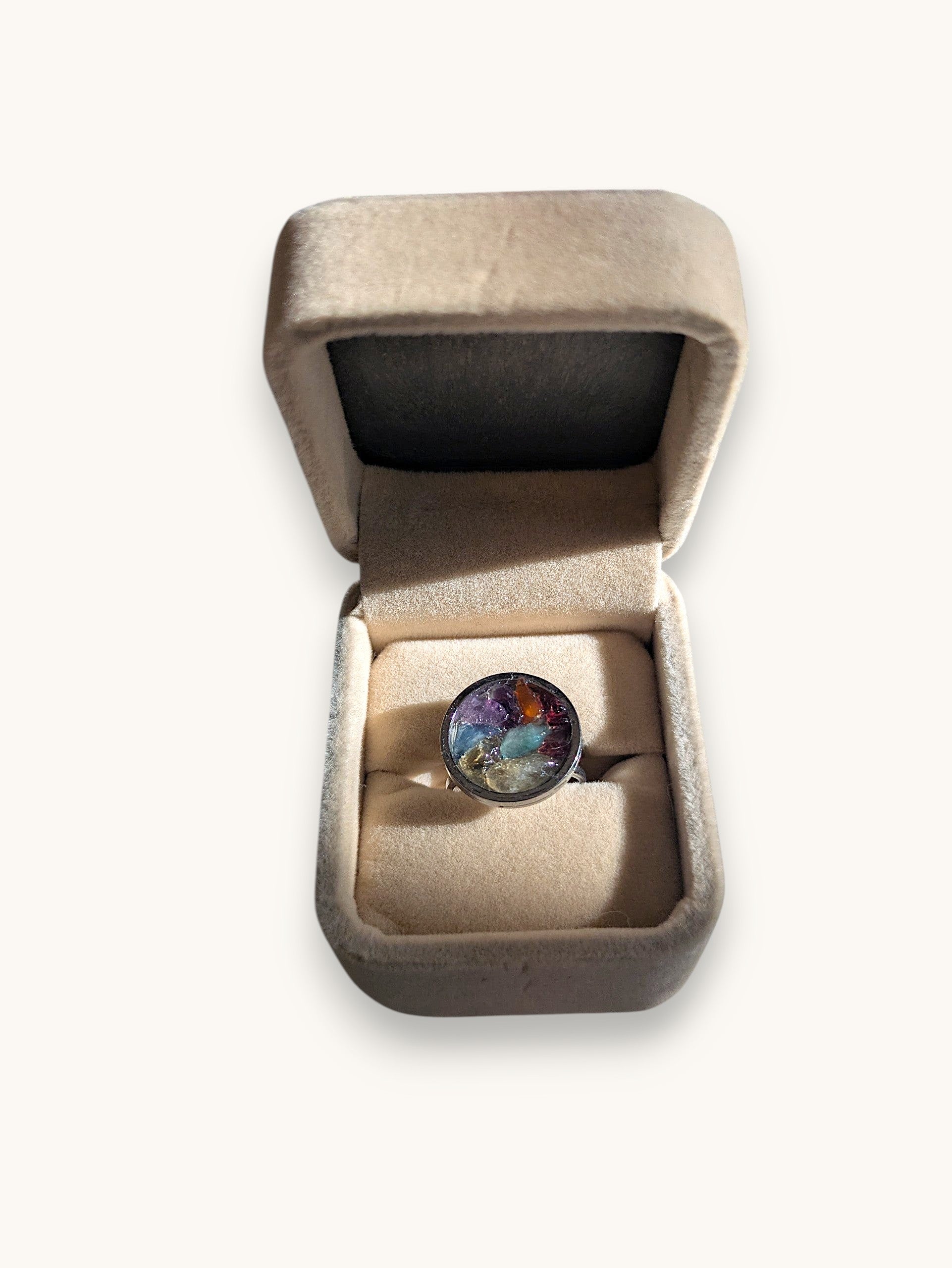 Citrinmagi handgjord ring med färgglada råa ädelstenar i rund silverfärgad infattning, presenterad i en beige ask.