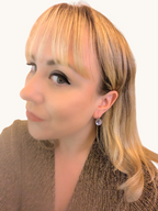 Citrinmagi eleganta runda hängande örhängen med subtil lyster burna av en kvinna för en sofistikerad look.
