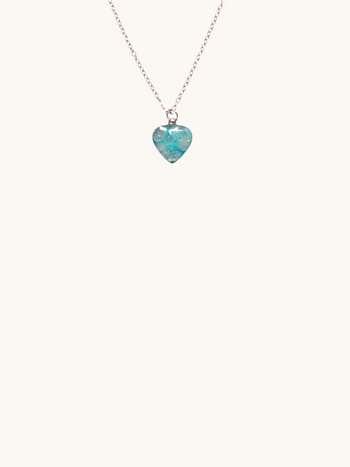 Citrinmagi halsband med silverfärgad kedja och ett blått hjärtformat hänge med subtilt mönster.