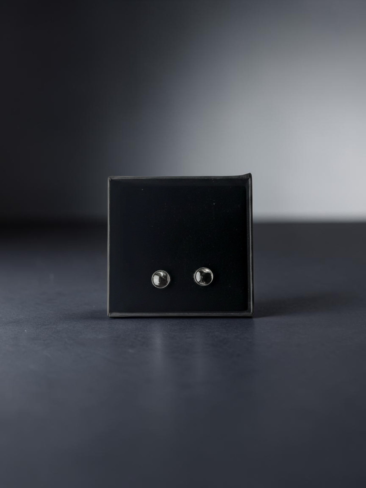 Citrinmagi örhängen med svart obsidian infattad i silverpläterat rostfritt stål, presenterade i en elegant ask.