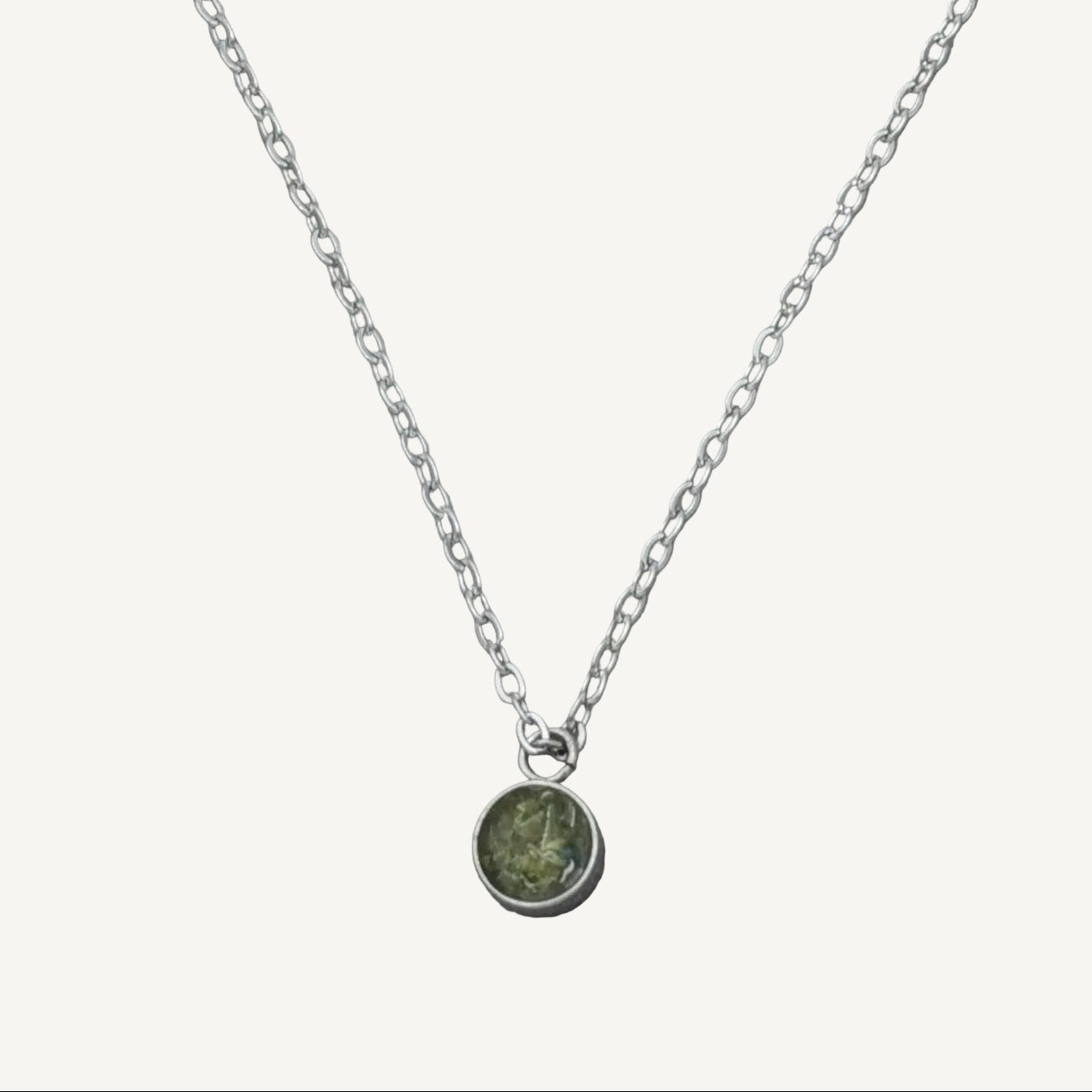 Handgjort silverhalsband med rund berlock infattad med äkta gröna peridot-kristaller från Nayuga Jewels