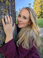 Kvinna bär Citrinmagi hjärtformad ring i silver med jordgubbskvarts mot en trädstam i en park.